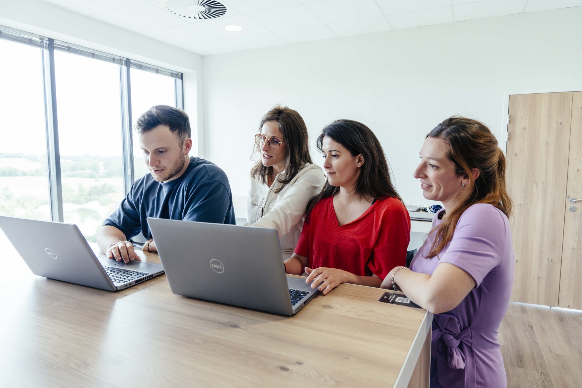 Quatre collaborateurs Yumens regardent dans la même direction un écran d'ordinateur